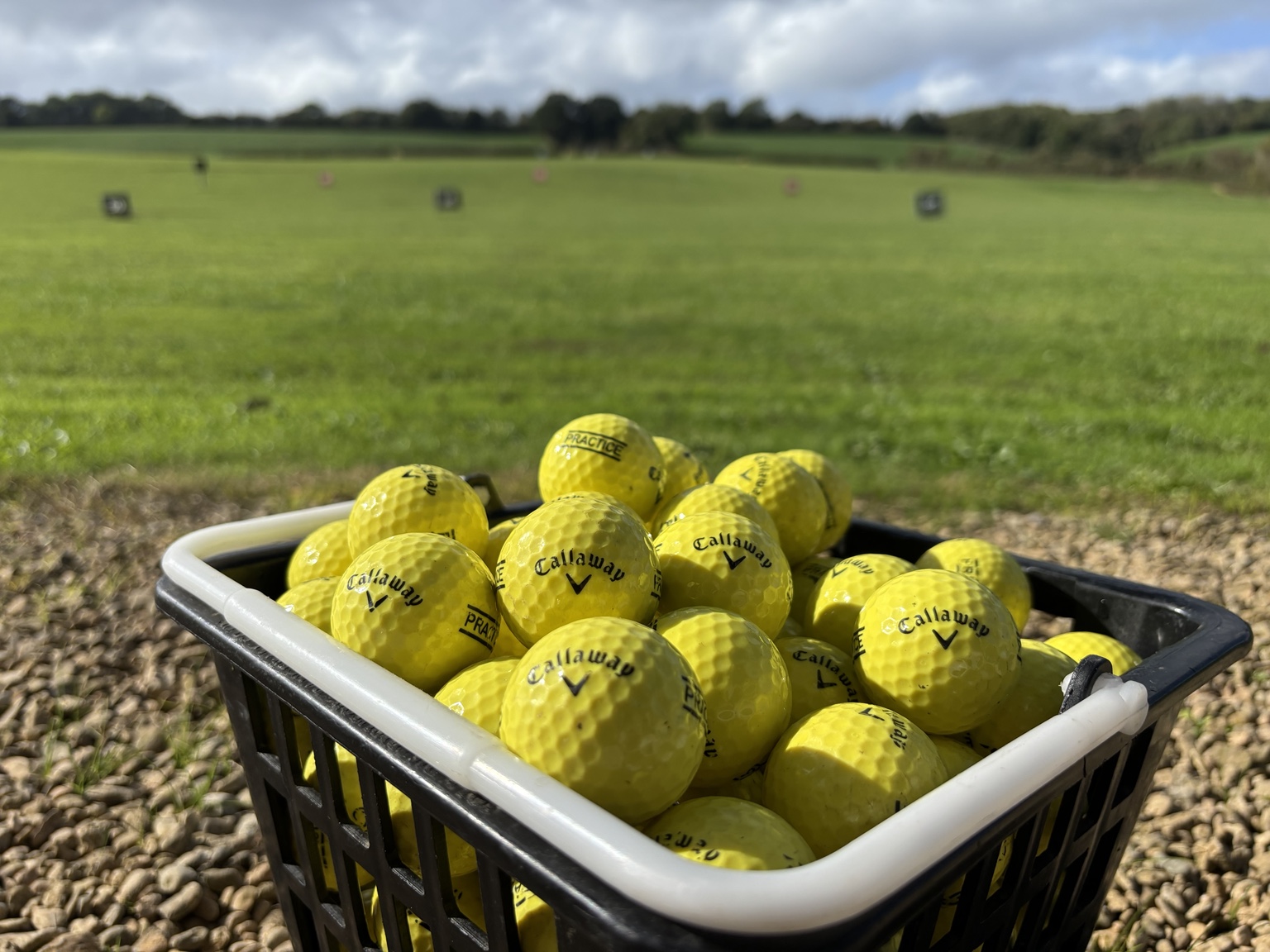 A basket of matching yellow Callaway practice balls ready for a range session